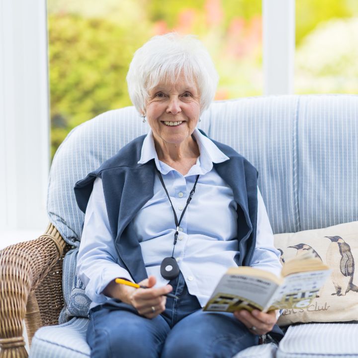 A lady relaxing at home with her pendant.